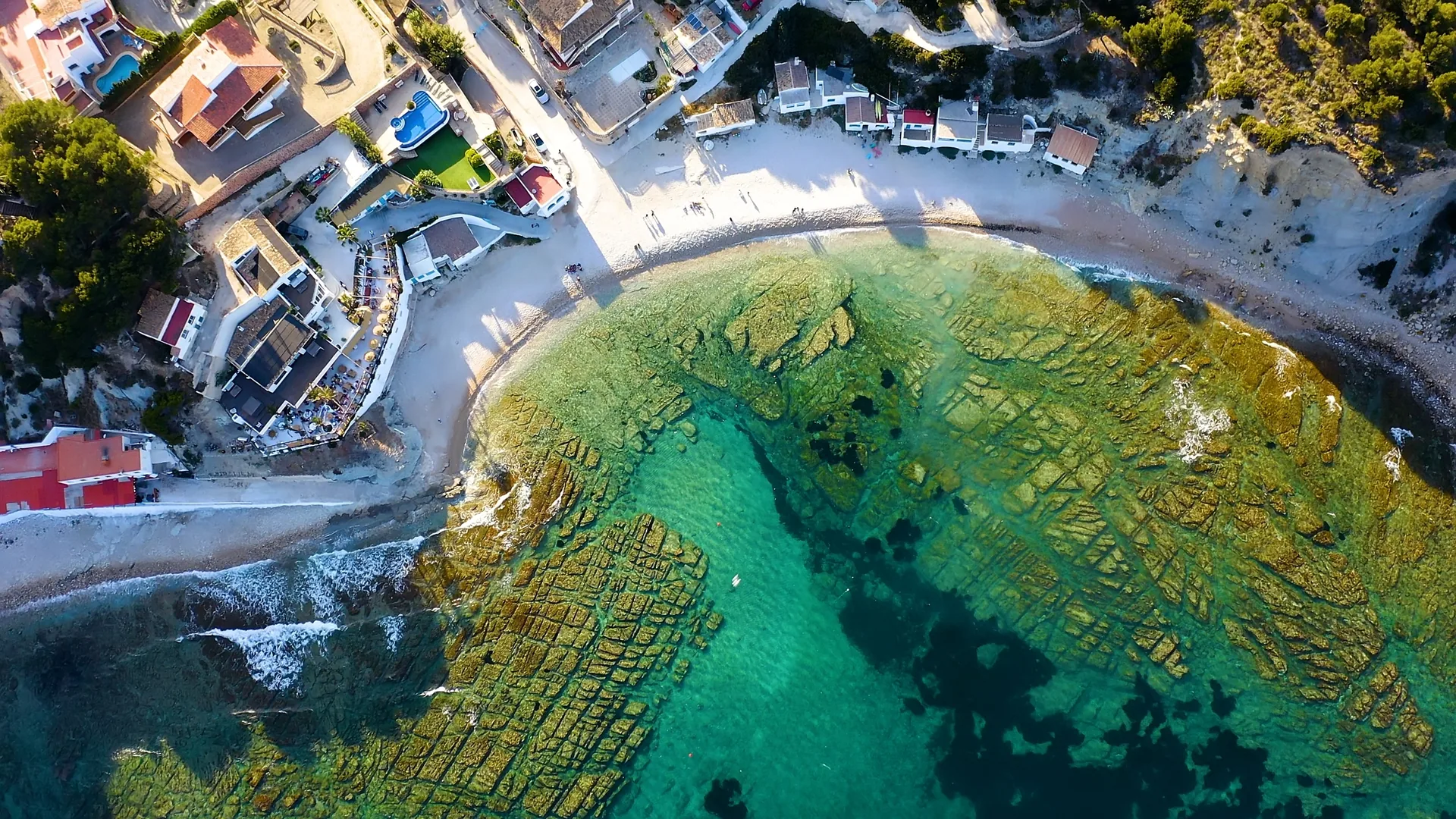 Vue aérienne de Cala Portitxol à Xàbia, petites maisons au bord de l’eau claire
