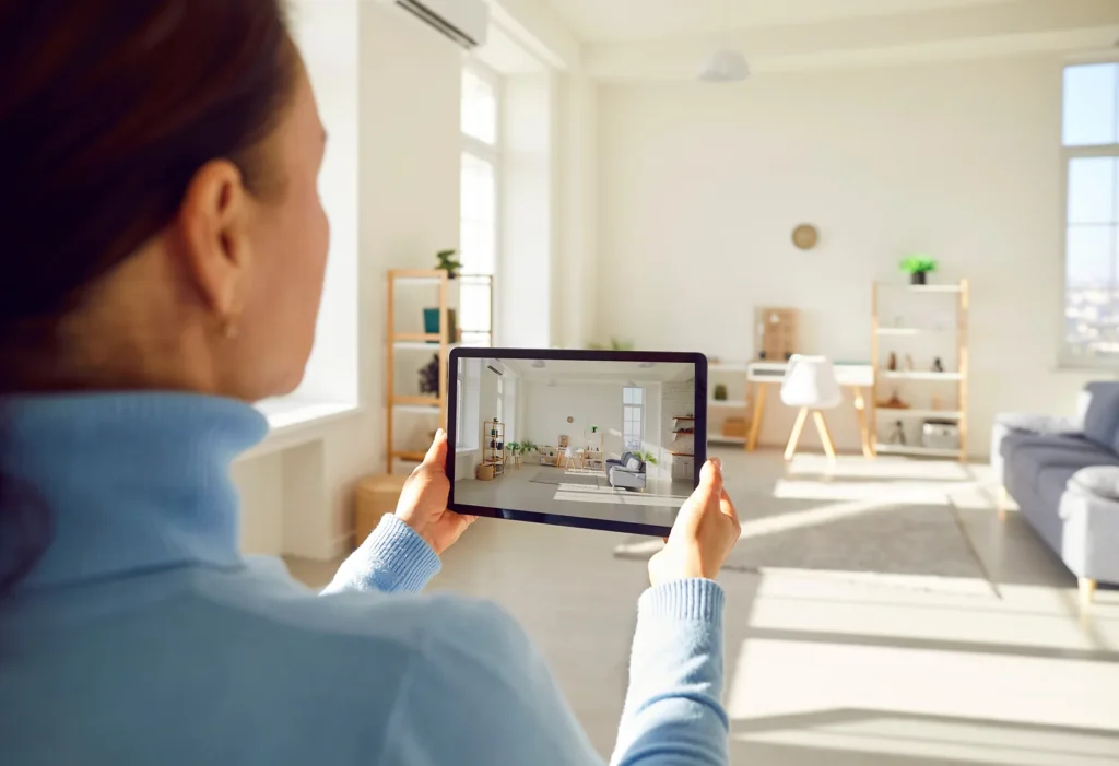 A person using a tablet to photograph and review a furnished room